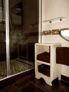 uma casa de banho com um chuveiro e um banco de madeira. em Le Chemin d'Ulphe em Boves