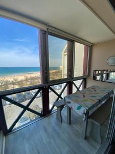a balcony with a table and a view of the ocean at Appartement vue mer Hossegor in Soorts-Hossegor