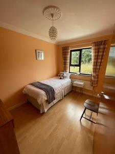 ein Schlafzimmer mit einem Bett, einem Fenster und einem Stuhl in der Unterkunft Heather Hill Cottage in Downings