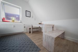 Zimmer mit einem Tisch, einer Bank und einem Fenster in der Unterkunft KobyApartment in Herford