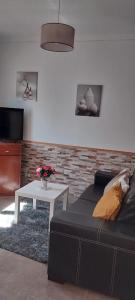 uma sala de estar com um sofá e uma mesa em Chez Rosa em Vila Real de Santo António