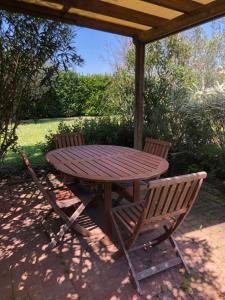 a wooden table and two chairs under a pergola at Spazio Friuli - Soreli Apt residenza nel verde in Sevegliano