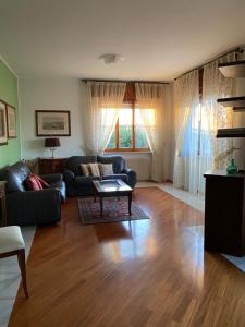 un soggiorno con un divano e un tavolo di Spazio Friuli - Soreli Apt residenza nel verde a Sevegliano
