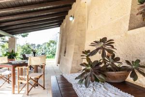 een patio met een tafel, stoelen en planten bij Agriturismo De Lorenzi in Casarano