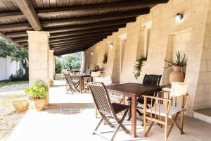 een houten tafel en stoelen op een patio bij Agriturismo De Lorenzi in Casarano