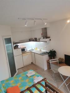 eine Küche mit weißen Schränken und einem Tisch und Stühlen in der Unterkunft Chicago Studio Apartment in Ohrid + 1 Foto