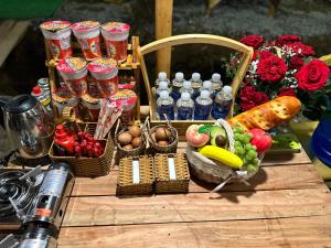 une table en bois recouverte de paniers de nourriture et de légumes dans l'établissement SAY Camp Forest, à Cần Giờ