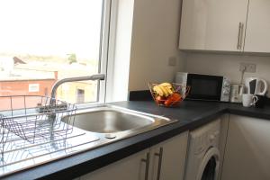 a kitchen counter with a sink and a bowl of fruit at 1Bed Apartment in Heywood with Transport Links in Heywood