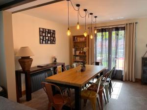 a dining room with a wooden table and chairs at Honfleur - grande maison familiale avec jardin in Honfleur