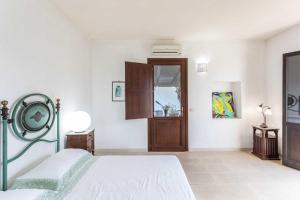 een witte slaapkamer met een bed en een raam bij Agriturismo De Lorenzi in Casarano