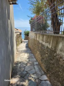 un chemin de pierre à côté d'un mur avec une clôture dans l'établissement Beau studio / Clim / Parking / Plage à 200 m, à San-Martino-di-Lota