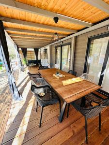 a wooden table and chairs on a covered deck at Sandra Holiday Homes in Biograd na Moru