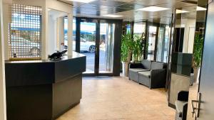 an office lobby with a reception desk and chairs at Hôtel de Flore in Saint-Raphaël