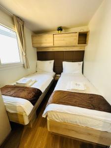 two beds in a small room with a window at Sandra Holiday Homes in Biograd na Moru