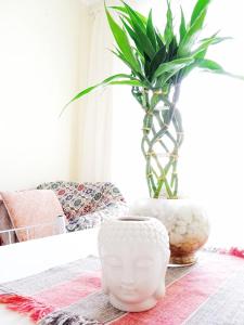 un jarrón blanco sentado en una mesa con una planta en Pôr do Sol 8 andar en Canoas
