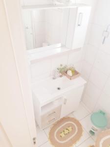 a white bathroom with a sink and a mirror at Pôr do Sol 8 andar in Canoas