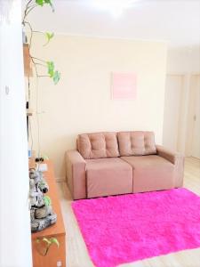 sala de estar con sofá rosa y alfombra rosa en Pôr do Sol 8 andar en Canoas