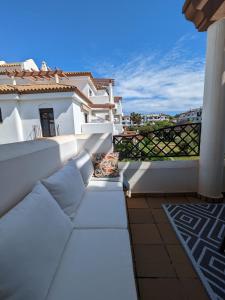a balcony with white furniture and a view of the ocean at APARTAMENTO EN COTO DE SANCTI PETRI in Chiclana de la Frontera