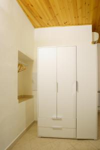 a white cabinet in a room with a wooden ceiling at Ca Torre in Riomaggiore