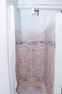 um chuveiro com uma cortina de chuveiro branca na casa de banho em Buttercup Cottage Apartments em Arnos Vale