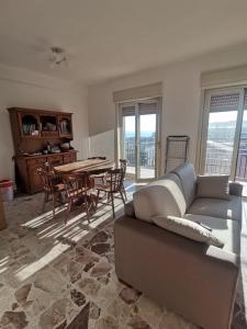 a living room with a couch and a table at Appartement Spadafora - 50m de la plage in Spadafora