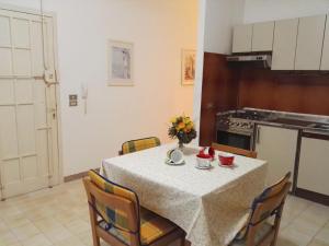 una sala da pranzo con tavolo e sedie e una cucina di Villetta mare blu Baia Verde a Gallipoli