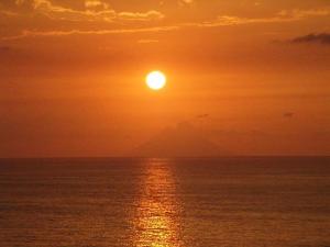 a sunset over the ocean with the sun in the sky at Appartement Spadafora - 50m de la plage in Spadafora