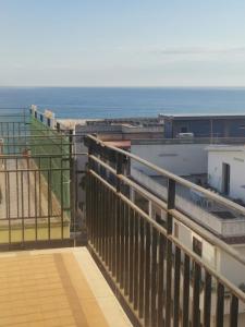 a view of the ocean from the balcony of a building at Appartement Spadafora - 50m de la plage in Spadafora
