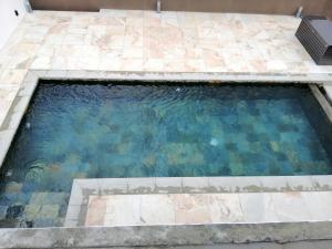 una piscina de agua en un suelo de baldosa en Faro Villa, en Centre de Flacq