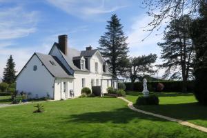 a white house with a statue in the yard at LE CLOS BRAYON in Saint-Honoré