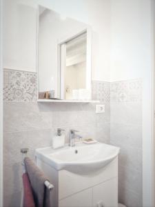 カステルヌオーヴォ・マグラにあるB&B il Lupo e la Querciaの白いバスルーム(シンク、鏡付)