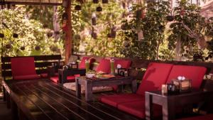 a patio with red chairs and a table and plants at Baan Manali Resort in Thongsala