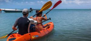 two people in an orange kayak in the water at Baan Manali Resort in Thongsala