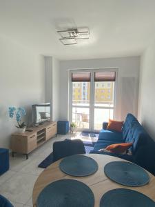 a living room with a blue couch and a table at Apartament Daszyńskiego in Suwałki