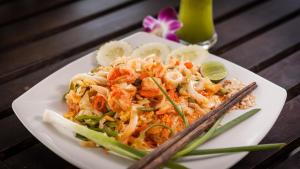 a plate of food with shrimp and vegetables on a table at Baan Manali Resort in Thongsala
