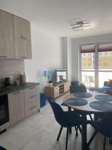a kitchen and living room with a table and chairs at Apartament Daszyńskiego in Suwałki