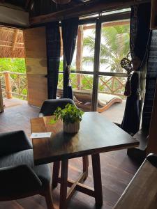 einen Tisch und Stühle in einem Zimmer mit Fenster in der Unterkunft El Paraiso Hotel Tulum in Tulum