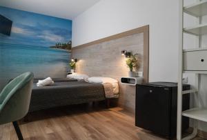 - une chambre avec un lit et une peinture sur l'océan dans l'établissement Hotel Ridomar 365, à Lloret de Mar