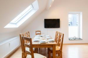 - une salle à manger avec une table et des chaises en bois dans l'établissement Stay and Work Apartment - 8 single beds - Garage, à Hau