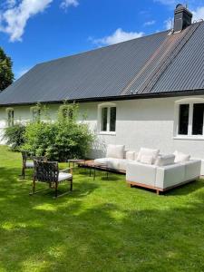 un patio con sofás y sillas frente a una casa en Slottsnära miljö., en Laholm