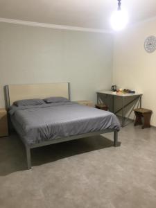 a bedroom with a bed and a table and a clock at Bardy guest house in Chʼiva