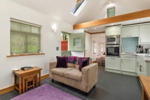 ein Wohnzimmer mit einem Stuhl und eine Küche in der Unterkunft The Woodland Retreat Pembrokeshire Dog-friendly in Haverfordwest