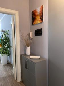 un armario en una habitación con teléfono y una pintura en Ralph Apartments, en Vlorë