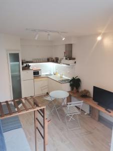 eine Küche mit einem Tisch und einem Tisch und Stühlen in der Unterkunft Chicago Studio Apartment in Ohrid