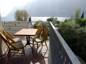 リーヴァ・デル・ガルダにあるHoliday Apartments Bellarivaのテーブルと椅子、水辺を見渡すバルコニー