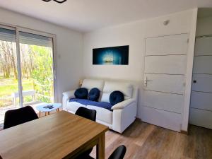 a living room with a couch and a table at La Maison de la Saye & SPA in Mios