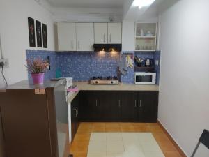 a kitchen with white cabinets and blue tiles at Lorin BnB in Kohīma