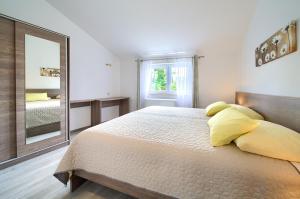 a bedroom with a large bed and a mirror at Apartmani DAL in Malinska