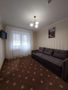a living room with a couch and a window at Apart-hotel 24/7 in Kamianets-Podilskyi