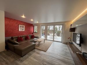 ein Wohnzimmer mit einem Sofa und einem Tisch in der Unterkunft 90 m2 Appartment with 2 Bedrooms, terrace and garden in Bad Friedrichshall
